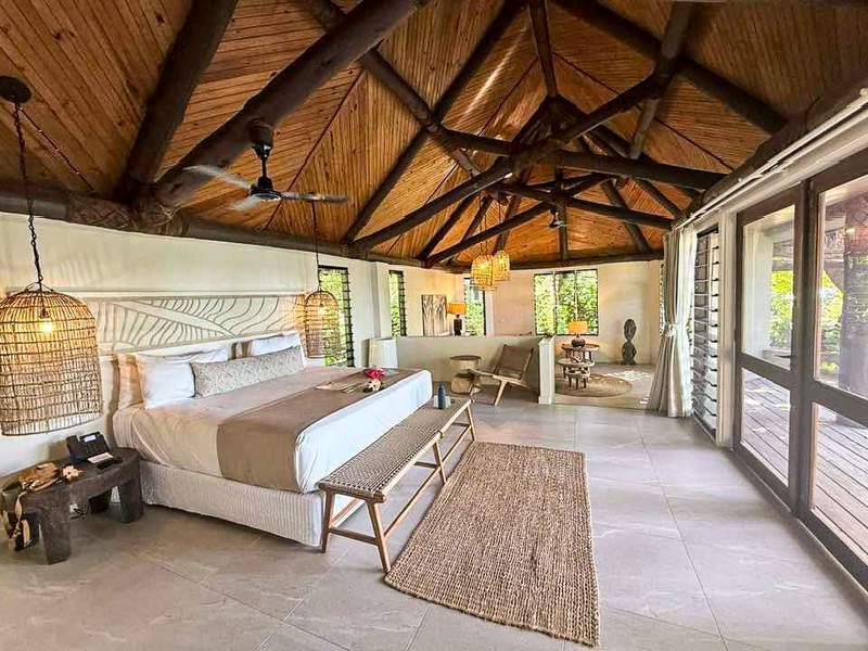 Airy bungalow interior with wood ceiling and wicker accents