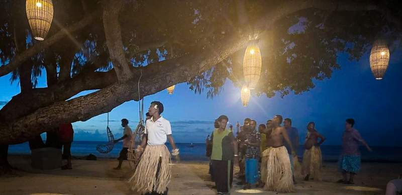 Cultural performance on the beach under a banyan tree in Fiji