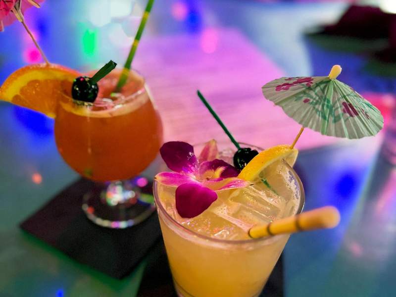 Two tropical cocktails at a Tiki Bar.