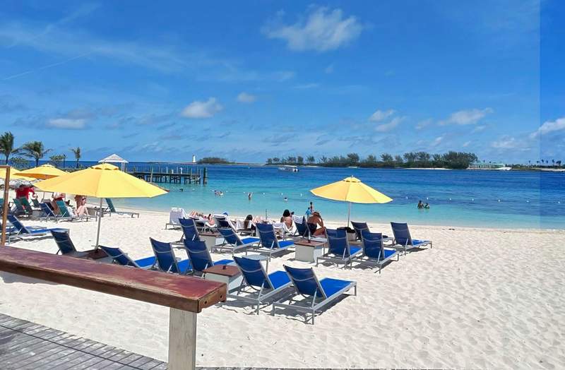 The private white sand beach at the British Colonial Nassau in the Bahamas featuring lounge chairs umbrellas and ocean views.