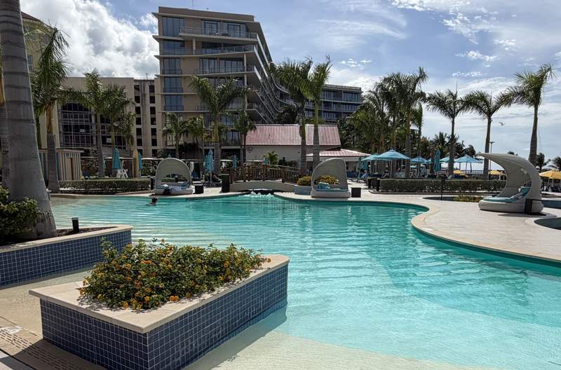 One of the oceanfront freshwater pools at the British Colonial Nassau resort in the Bahamas featuring luxury pool loungers and palm trees.