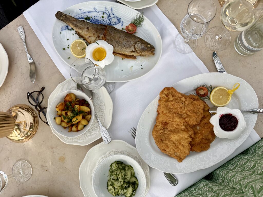 Overview of a restaurant table with a plated whole trout and schnitzel in Wiesbaden, Germany
