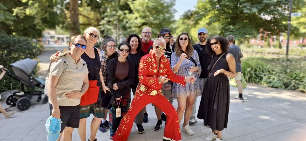 Group of adults posing in Bad Nauheim with a red-suited Elvis impersonator