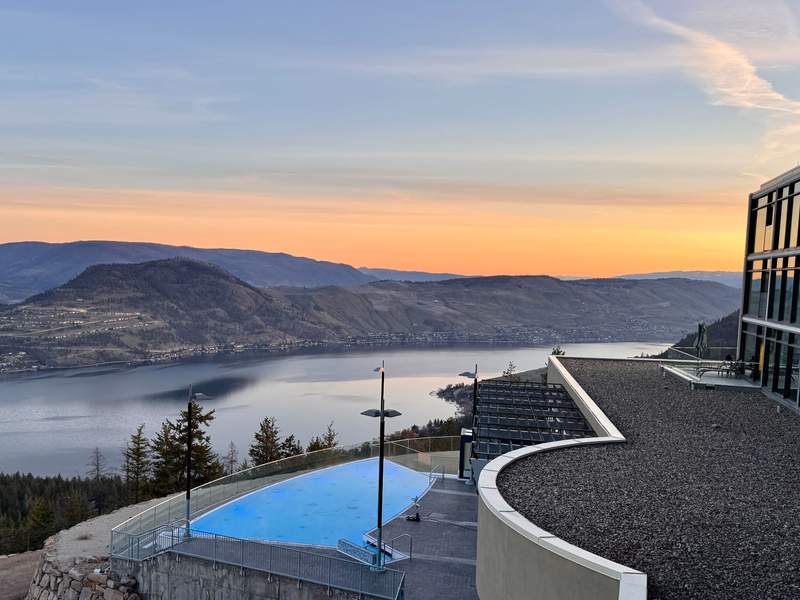 Outdoor pool overlooking Okanagan Lake at sunrise.