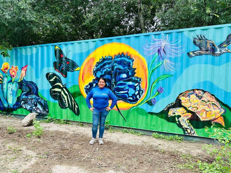 Executive Director Stephanie Lopez shows off a mural at the Butterfly Center