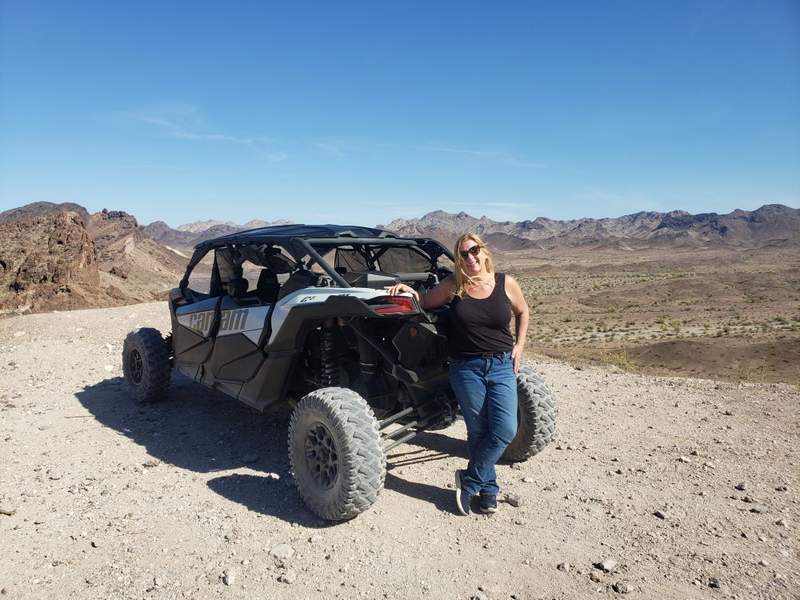 High-powered UTV off-road vehicles parked along a rugged desert trail overlooking scenic mountains in Lake Havasu.