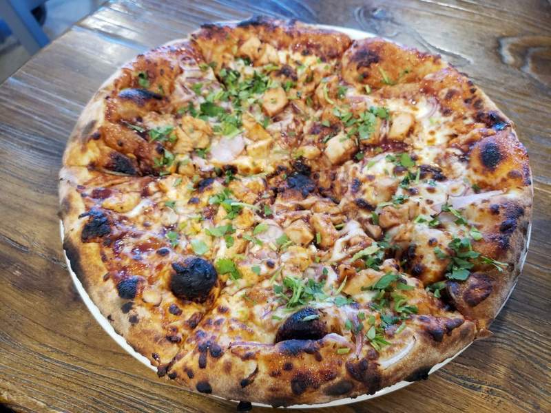 A freshly baked brick-oven pizza served on a wooden board at Mudshark Brewery in Lake Havasu City.