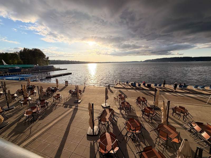 Tables and chairs with folded umbrellas overlooking Lake Washington
