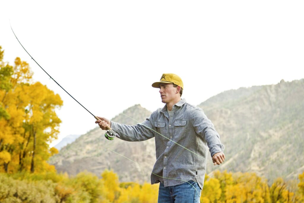 Angler fly fishing a river near Cody, Wyoming in fall