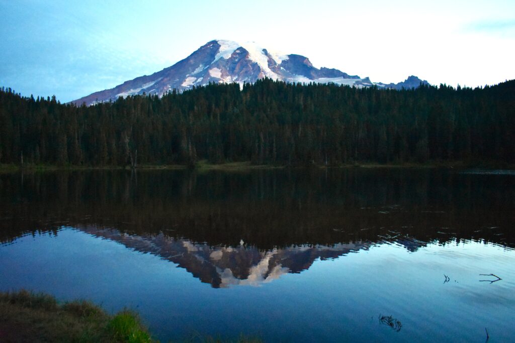 Mount Rainier reflecting on a lake as the sun rises