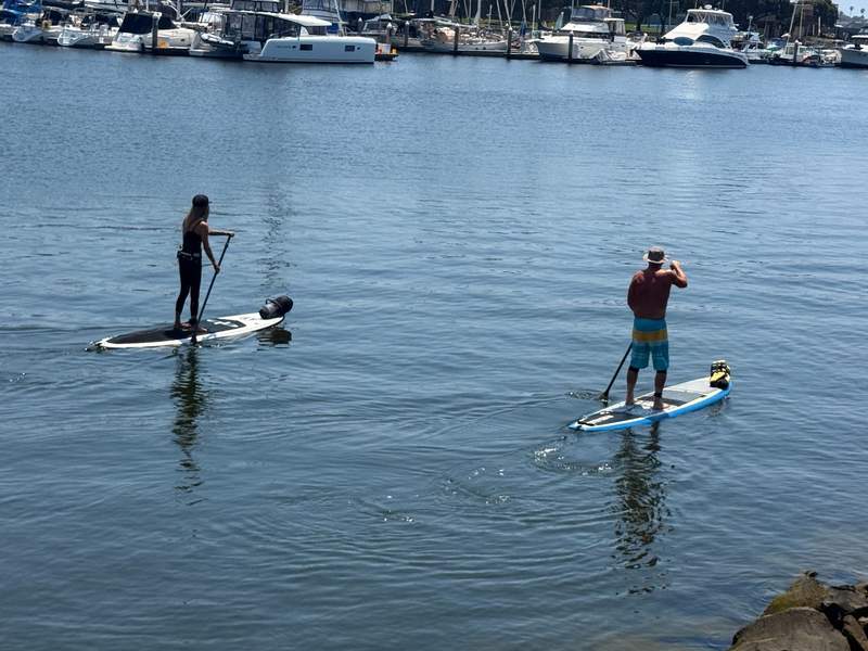 Two kayakers paddle their paddleboards in Channel Islands Harbor