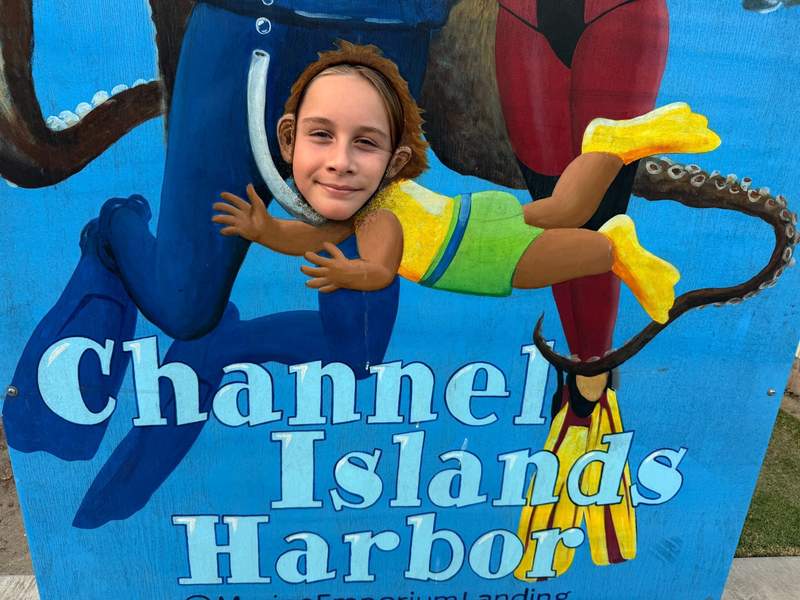 A girl's face peeks through funny painting at Oxnard's Channel Island's Harbor