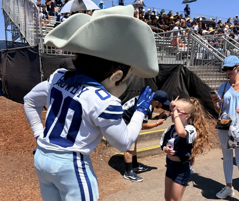 Rowdy, the mascot, cheering with a young fan at the Dallas Cowboys Oxnard, CA Training Camp