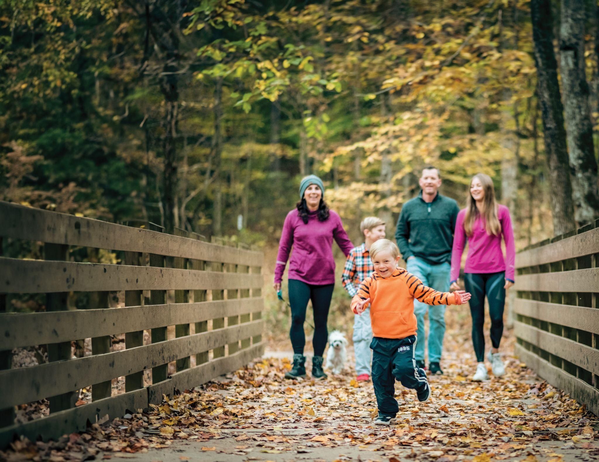 a family walking across a bridge .