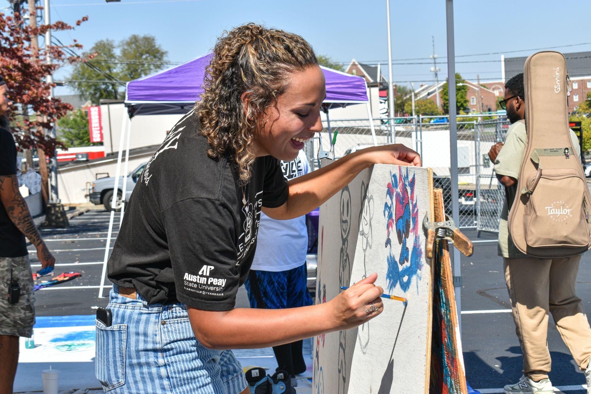 A girl painting a sign.