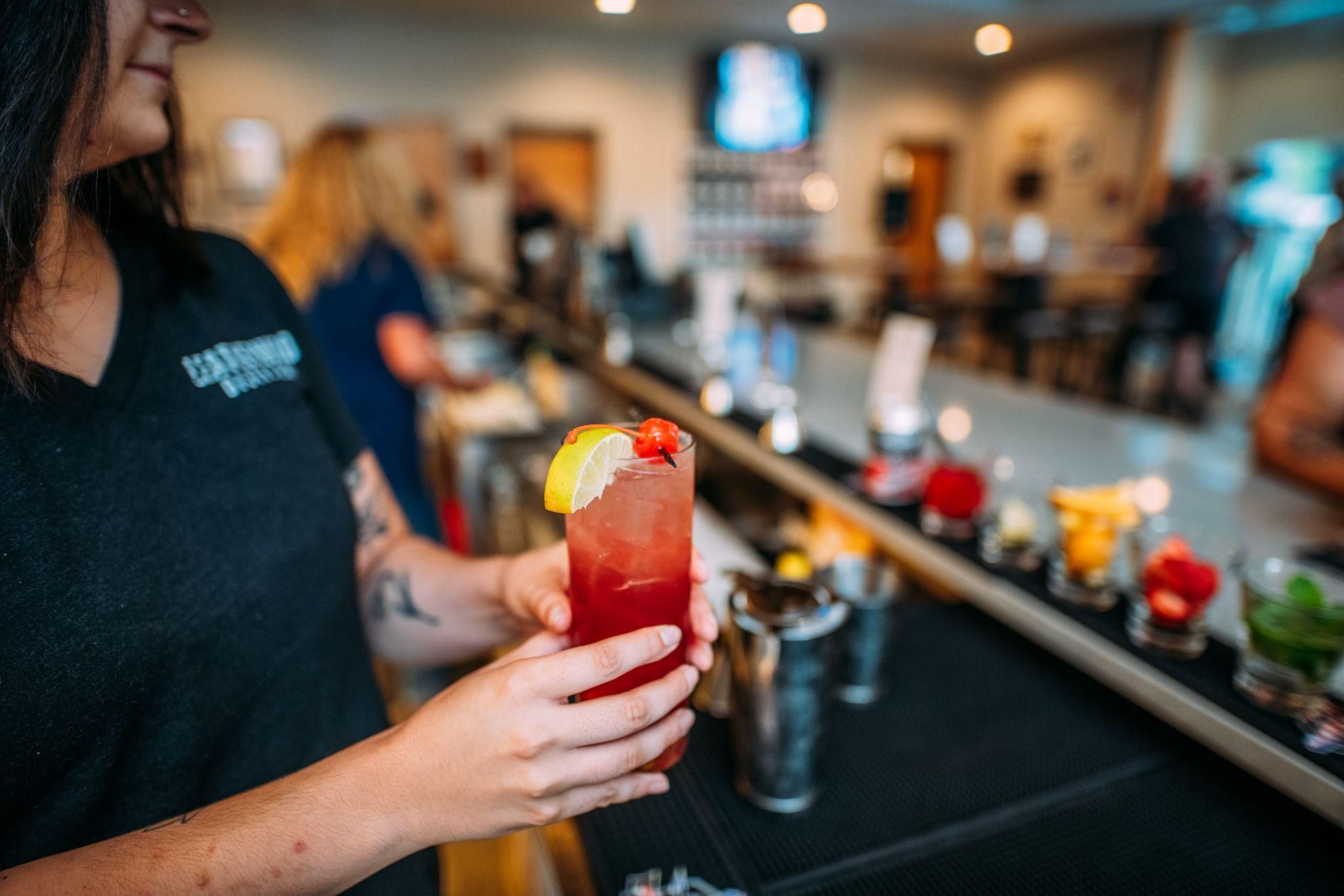 A woman serving a cocktail. 