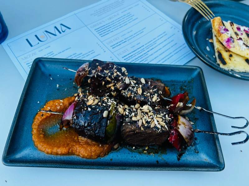 Slow braised short rib kebab adorn my plate at LUMA, with menu and naan bread in the background