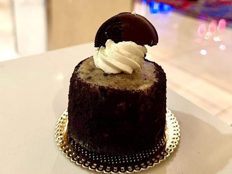 Individual Oreo cheesecake on gold plate with gold glitter.