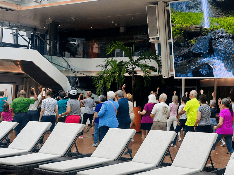 Guests participating in a line dancing class aboard a Holland America cruise ship