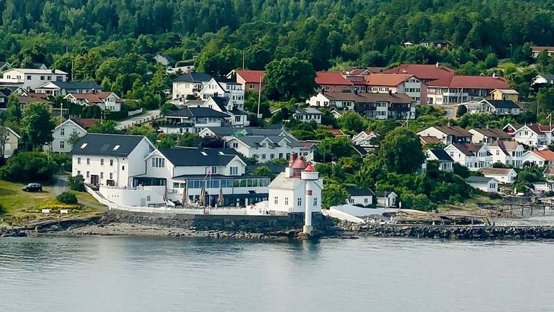 Coastal village and lighthouse along a Norwegian fjord