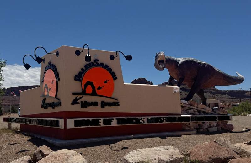 Horizontal outdoor view of life-size dinosaur statues along at Moab Giants in Moab Utah