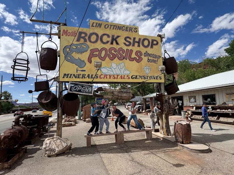 Horizontal view of sign for the Moab Rock Shop which features colorful rocks fossils and geological specimens.
