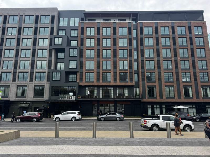 The Junto Hotel's front entrance and modern brick exterior, photographed from COSI.