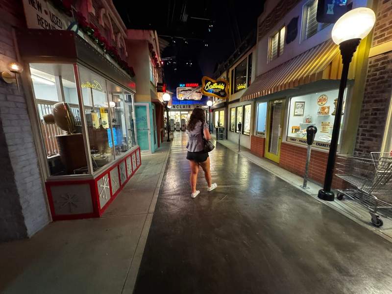 My daughter exploring COSI’s Progress exhibit, which highlights the evolution of technology and innovation with life size street and storefronts. 