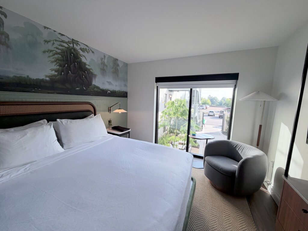 King guest room with exposed brick and historic details at The Hotel Monroe