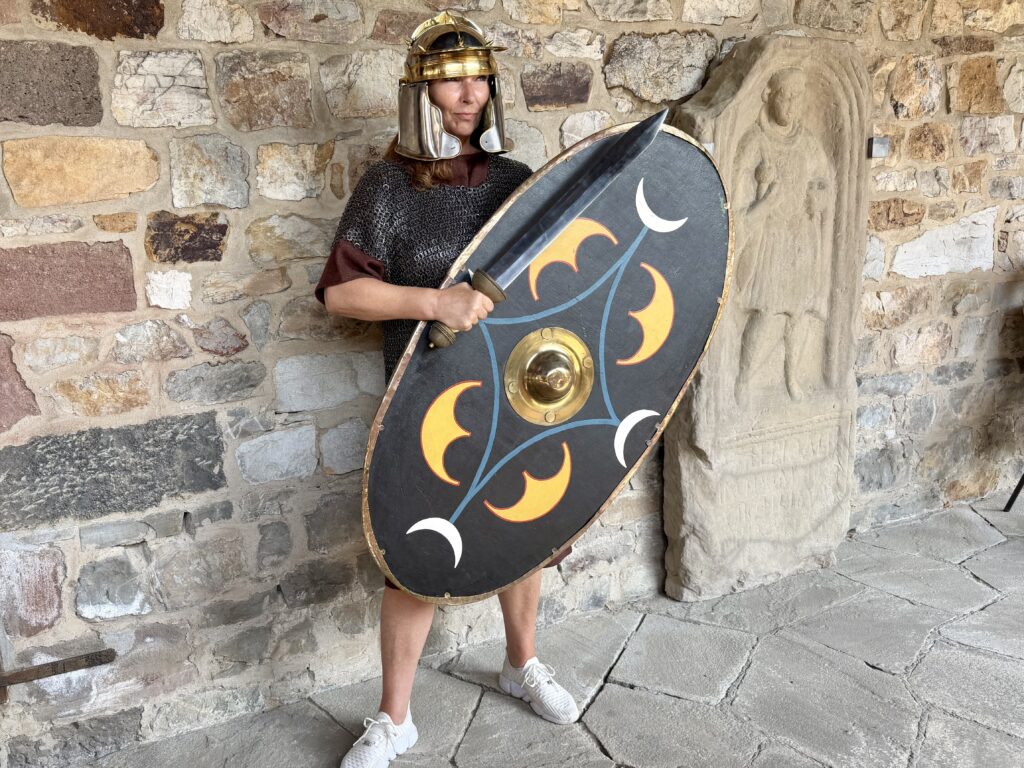 Woman dressed in historic Roman soldier ensemble at Saalburg fort in Germany.