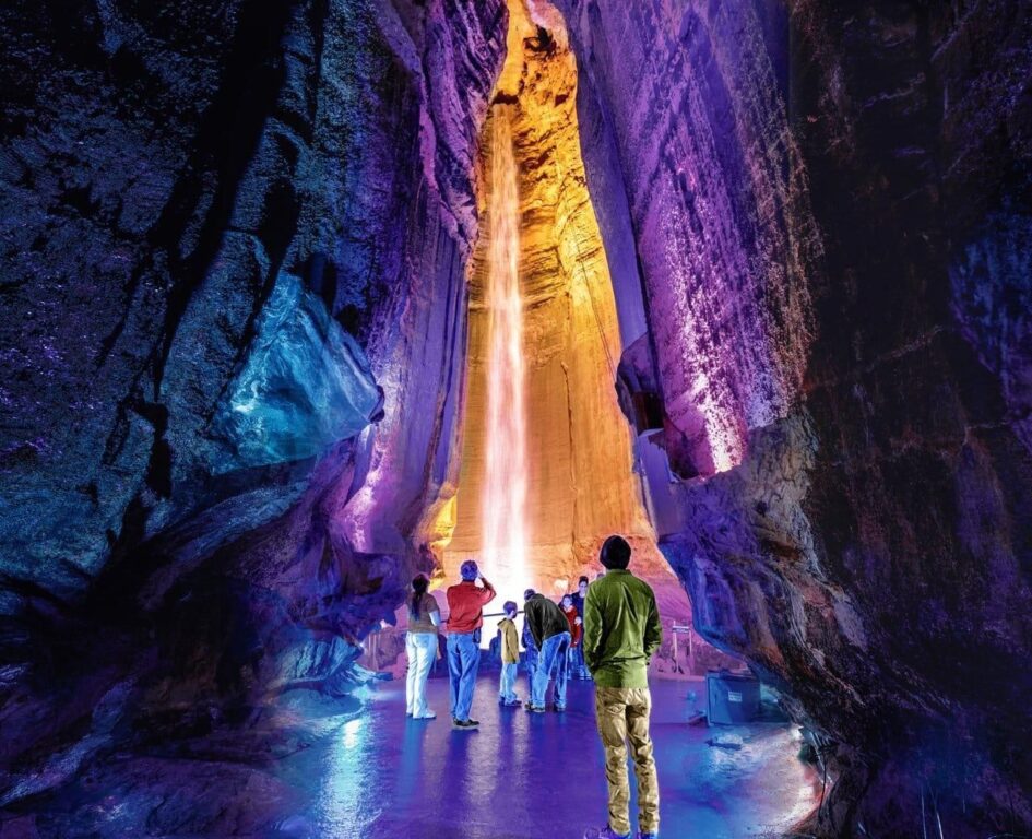 Underground waterfall inside Lookout Mountain illuminated by colorful lights