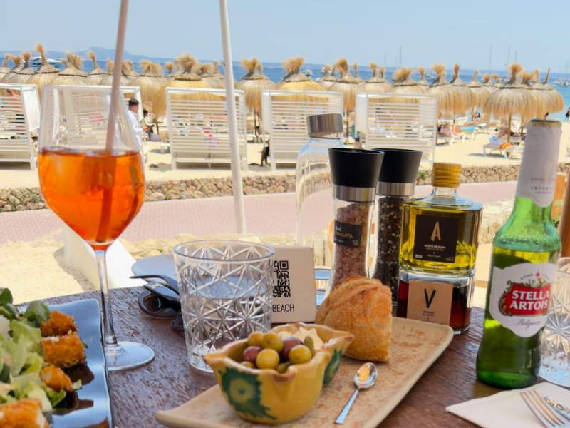 Bread, olives, olive oil, drinks and appetizers on a Beso Beach table overlooking the beach