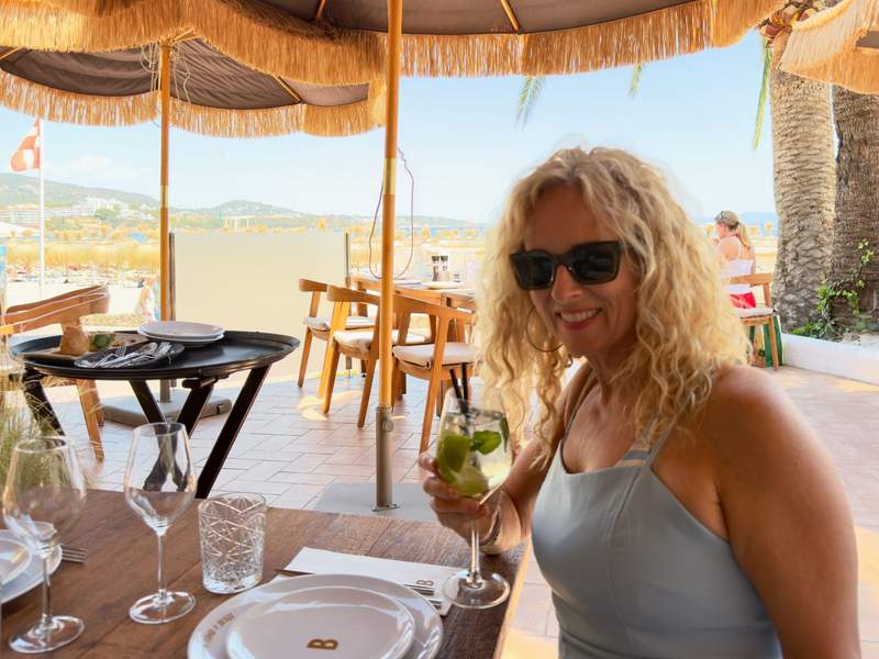 Author sipping a cocktail at an open-air Beso Beach table overlooking the Med.