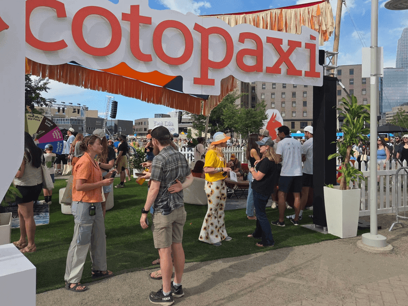 Festival attendees gathered at an outdoor gear brand booth