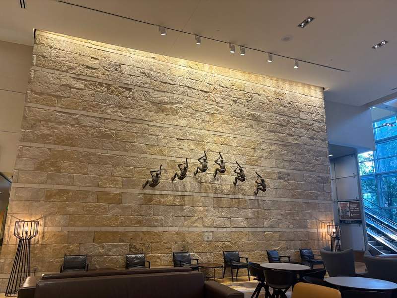 Hotel lobby with a stone accent wall featuring metal climber sculptures