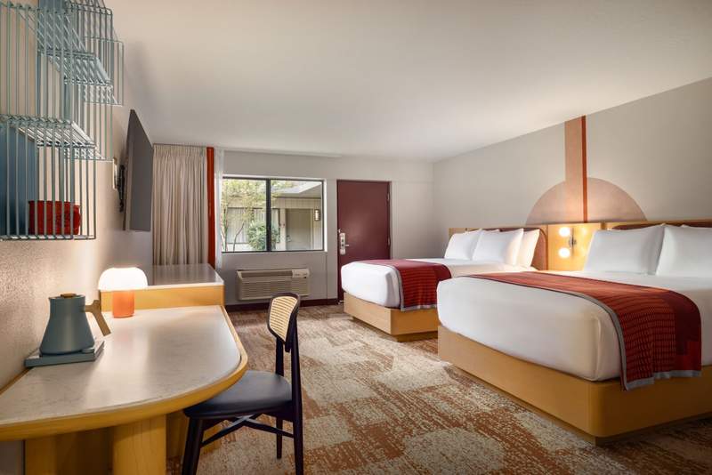 Deluxe guest room at Outbound Sedona with two queen beds, Southwestern-inspired accents, work desk and large window.