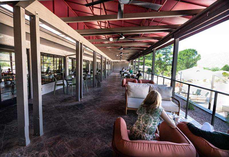 Covered outdoor dining terrace at Outbound Sedona overlooking the pool and surrounding red-rock landscape.