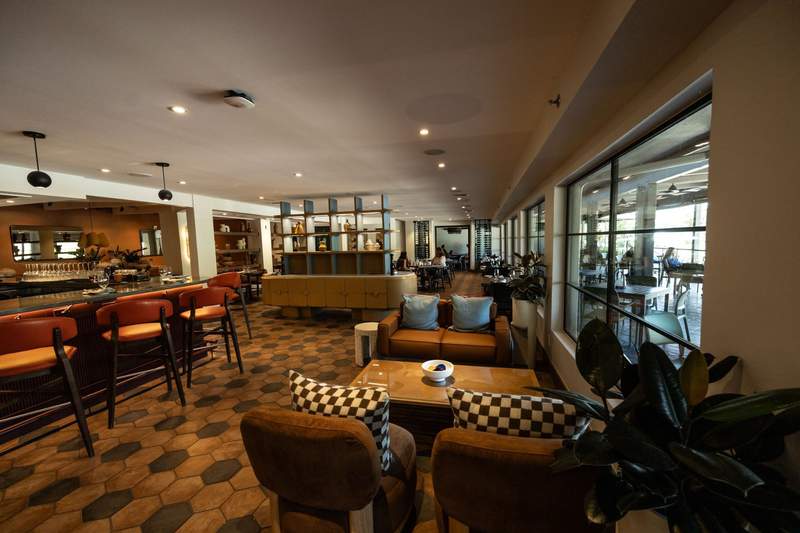 Contemporary restaurant and bar at Outbound Sedona with warm-toned furnishings, geometric tile and large windows opening to the terrace.