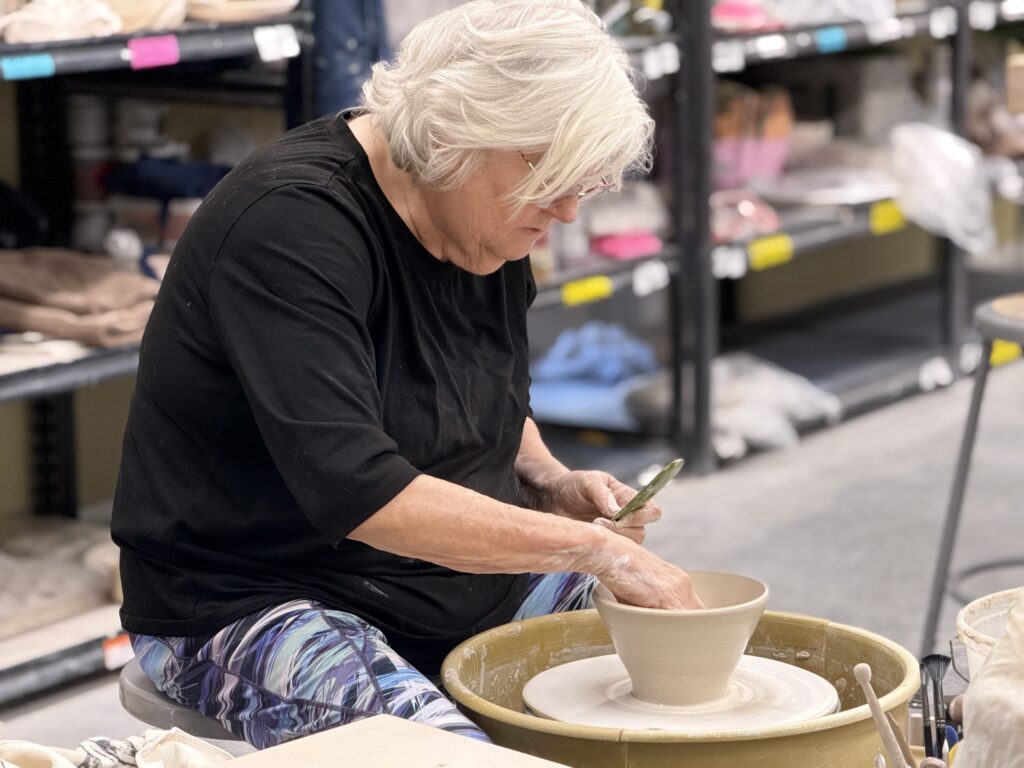 Senior woman throwing pottery on a wheel