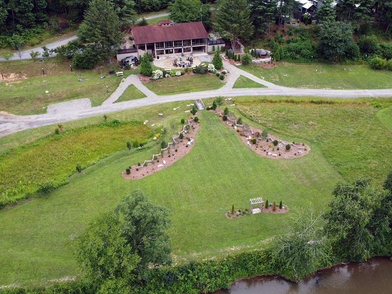 Outdoor wedding venue with a garden arbor overlooking the French Broad River and wooded mountain scenery