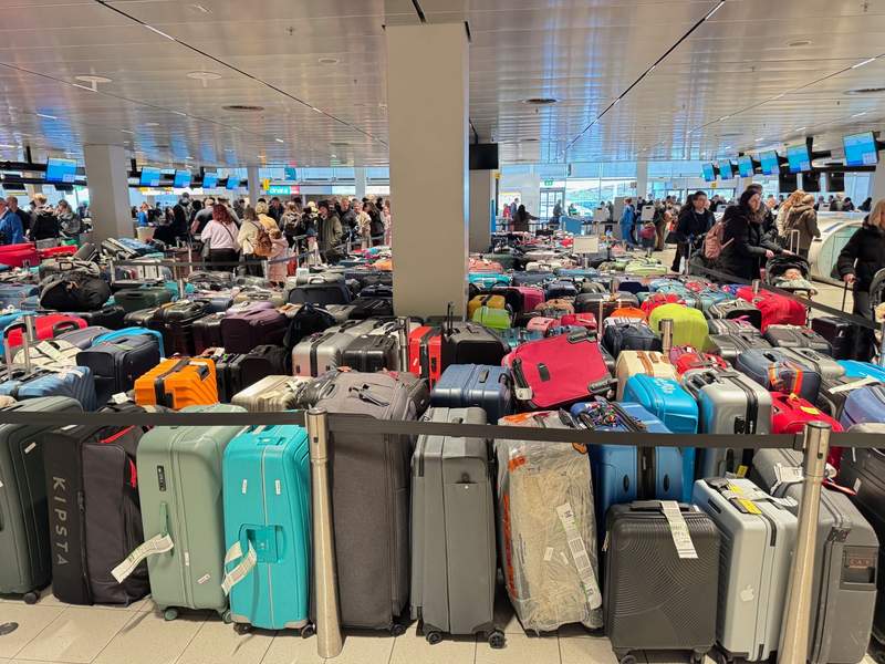 Hundreds of colorful suitcases waiting to be claimed at an airport.