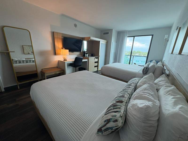 Hotel room with two beds desk and large window at Cambria Hotel Fort Lauderdale Beach