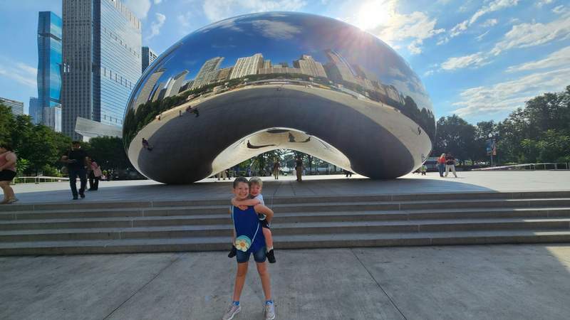 Two kids standing in front of the famous Bean in Millennium Park Chicago