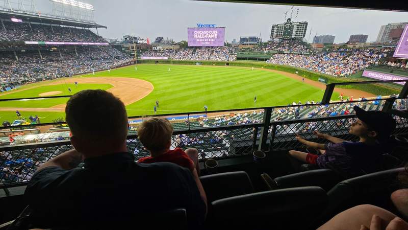 Several silhouetted figures watching a baseball game at Wrigley Field