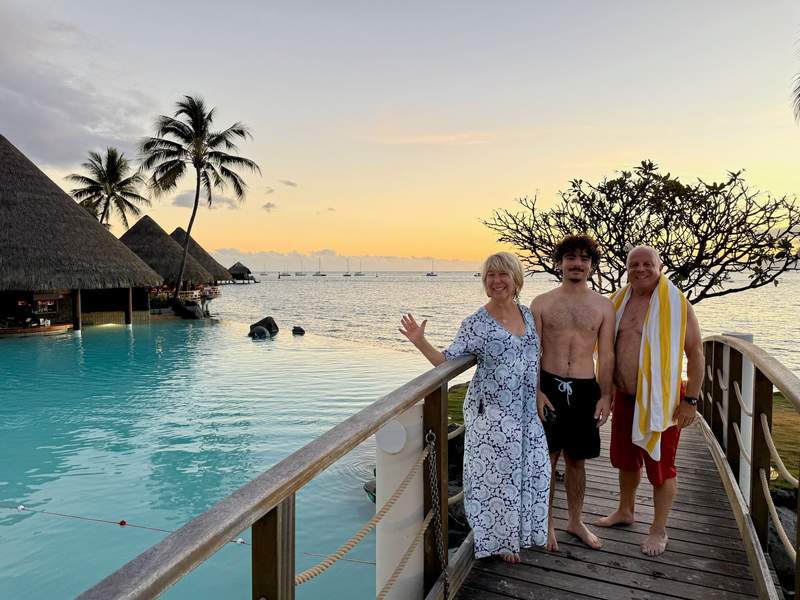 Author and family standing on a bridge by the infinity pool at sunset.