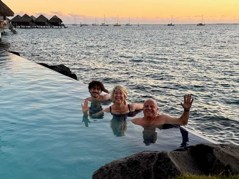 Closeup of author’s family in infinity pool overlooking the sea at sunset. 