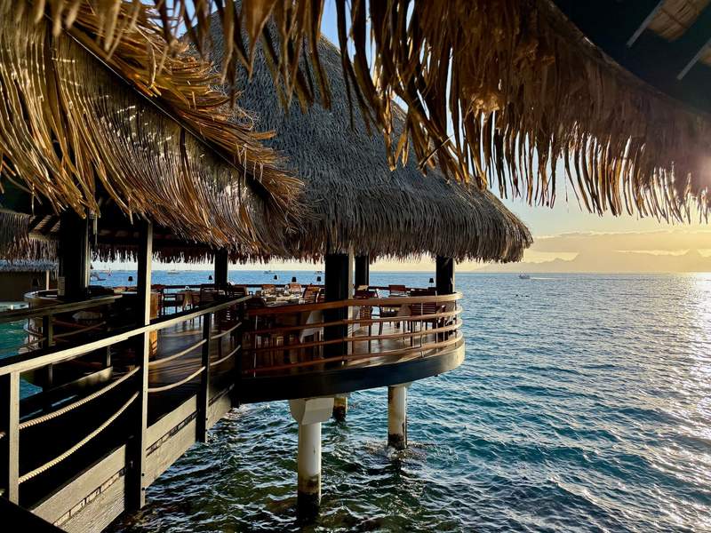 Looking out past the overwater restaurant to the ocean at sunset.