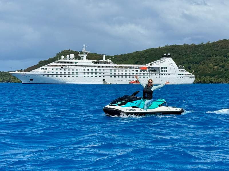 Author posing on a jet ski with the Windstar Cruises Star Breeze in the background.