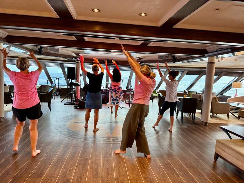 Women dancing on deck overlooking the bow of the ship.