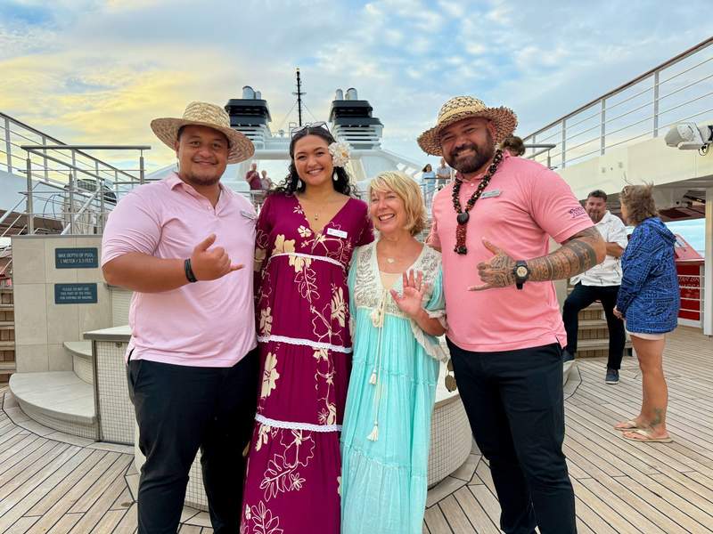 uthor standing with 3 cultural ambassadors on pool deck of the Star Breeze. 